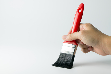 Hand holding paint brush on white backgroundの写真素材