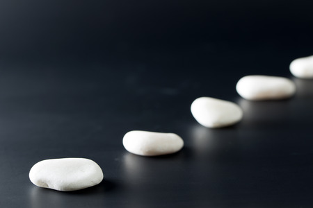 Path of white stones over black backgroundの写真素材