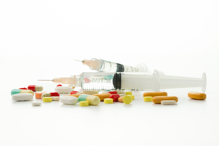 Assorted medical drugs and syringe on white backgroundの写真素材