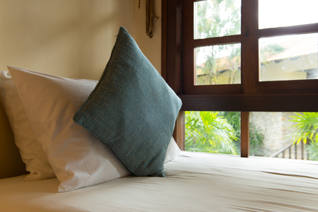 Close up of bed with large window to a tranquil garden viewの写真素材