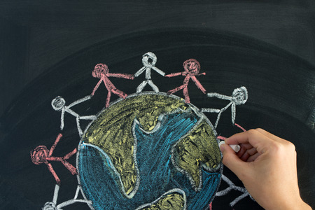 Hand drawing people holding hands around the earth on chalkboardの写真素材
