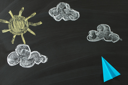 Paper plane flying in the sky, with sun and cloudsの写真素材