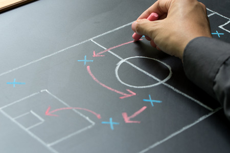 Man planning for a football strategy on blackboardの写真素材