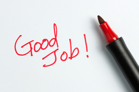 Hand writing good job word or text with red marker pen isolated on white backgroundの写真素材