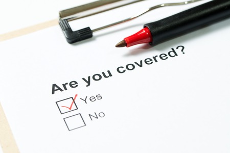 Are you covered questionnaire on clipboard with a red penの写真素材
