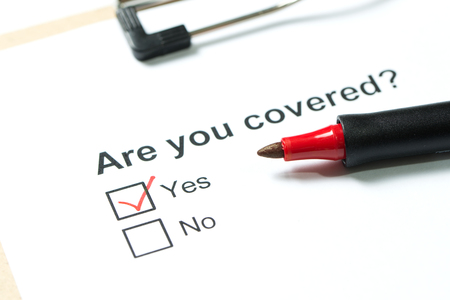 Are you covered questionnaire on clipboard with a red penの写真素材