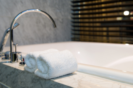 White bathroom towel on a white marble bathtubの写真素材
