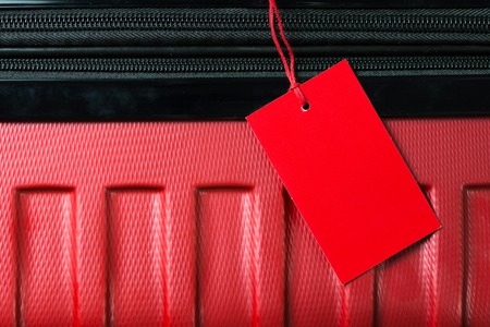 Red color empty travel luggage label on handleの写真素材