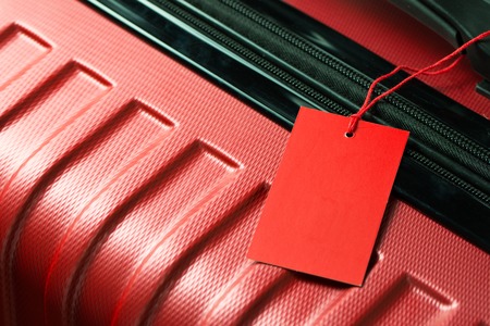 Red color empty travel luggage label on handleの写真素材