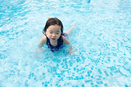 Portrait of Asian little baby girl playing in swimming poolの写真素材