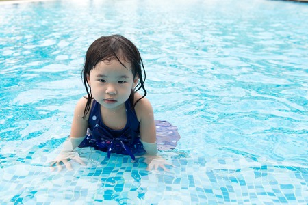 Portrait of Asian little baby girl playing in swimming poolの写真素材