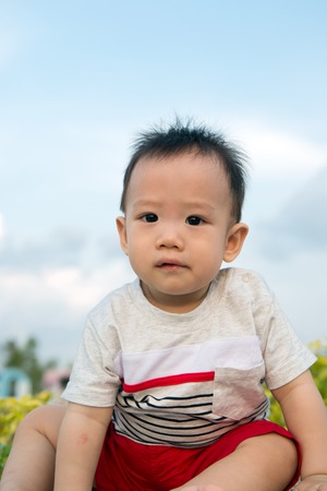 Portrait of Asian baby boy outdoor against blue skyの写真素材
