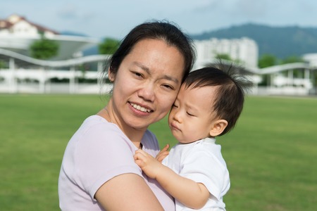 Portrait of an Asian mother with her son outdoorの写真素材