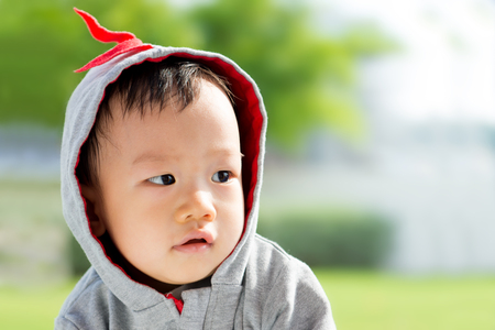 Portrait of little Asian baby boy at outdoor parkの写真素材