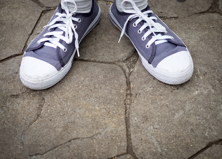 Top view of sneakers on legs on concrete floorの写真素材
