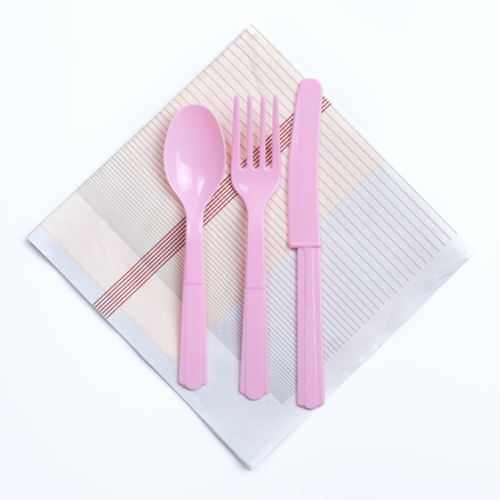 Pink color plastic fork, spoon and knife on napkin ready for kid partyの写真素材