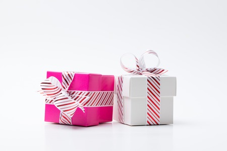 Pink and white color gift boxes tied with white red stripe ribbon isolated on white background