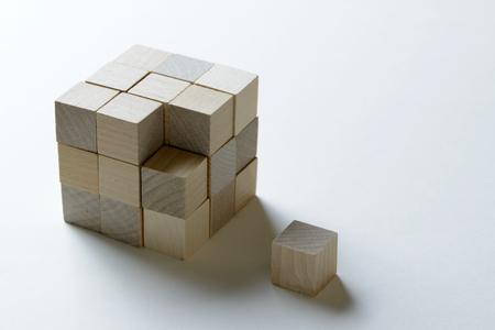 Last missing piece wood cube to complete a bigger blockの写真素材