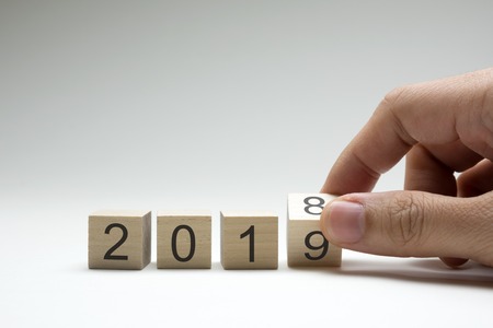 Hand is turning a wooden cube symbolically changes from 2018 to 2019の写真素材