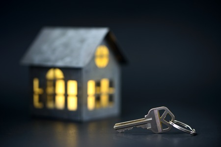 House keys with house model on the backgroundの写真素材
