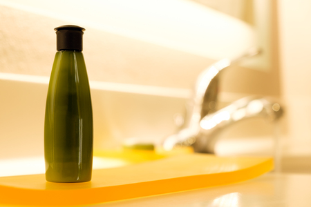 Green small cosmestic container lotion, shampoo or body gel in bathroomの写真素材