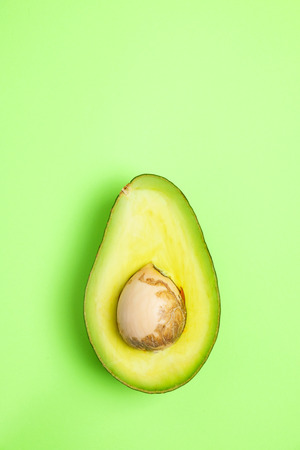 Top view avocado slice fruit on the green backgroundの写真素材