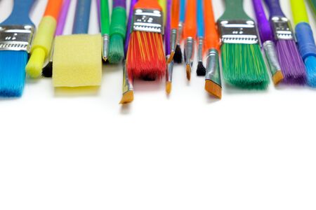 Row of artist paint brushes closeup on white