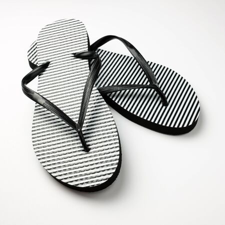 Pair of black and white stripe flip flops isolated on whiteの写真素材