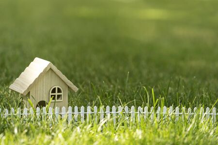 Little house on green grass field in sun light for real estate propertyの写真素材