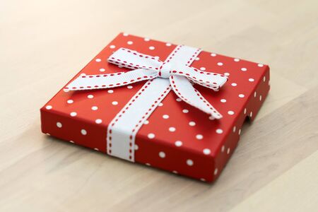 White polka dots red color gift box on wooden backgroundの写真素材