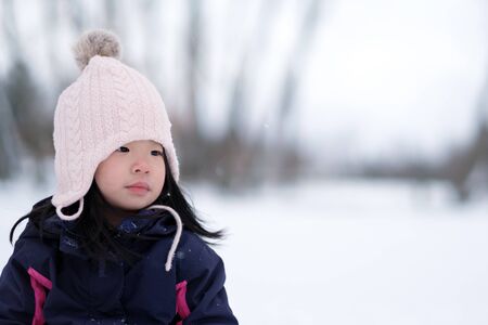 Winter portrait of little asian child girl wearing knitted hatの写真素材