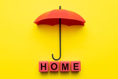 Red umbrella protecting home for house insurance conceptの写真素材