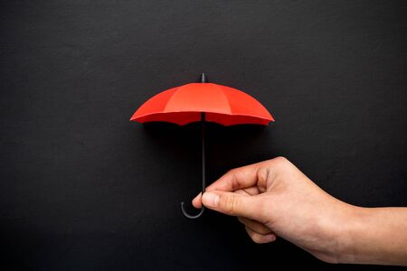 Hand hold a red umbrella 3D icon isolated on blackの写真素材