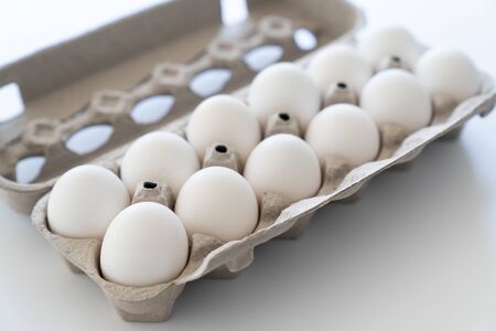One dozen white eggs in a carton package