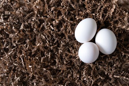Lay flat view three white chicken eggs