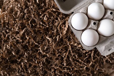 White eggs in a carton package in nestの写真素材