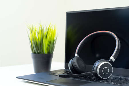 Headphone with laptop in office for customer service, call center or telecommunication concept