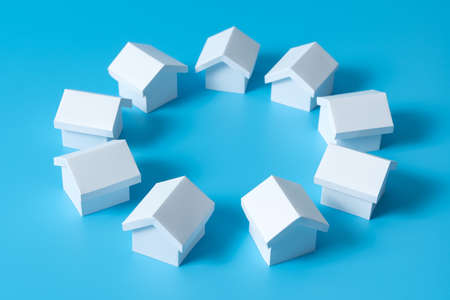3D white houses model in circle on blue background for real estate property, housing development or communityの写真素材