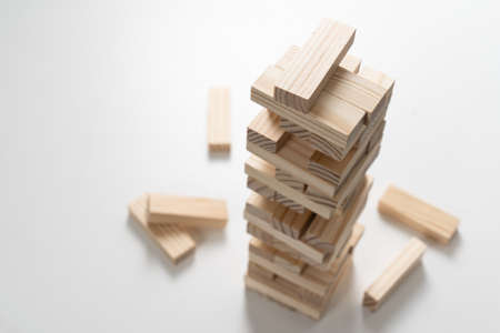 Closeup wood blocks stack game for planning, risk and strategy of project management in business...
