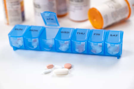 Blue color medicine organizer with prescription bottles isolated on white backgroundの写真素材