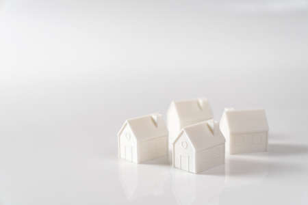 Miniature 3D printed model house on white background for home or real estate marketの写真素材