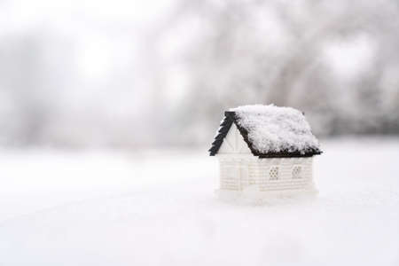 Miniature 3D model house on snow for winter season, real estate, property or rental marketの写真素材