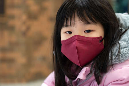 Coronavirus Covid-19, portrait of little asian kid girl wearing red color face maskの写真素材