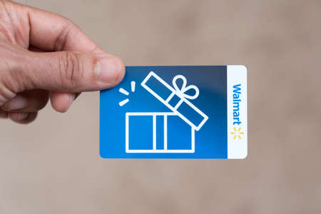 Detroit, USA - May 31, 2022 : Hand holding a Walmart blue color gift card isolatedのeditorial素材