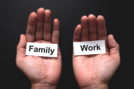 Man hand trying to balance the word of family and work for work life balance conceptの写真素材