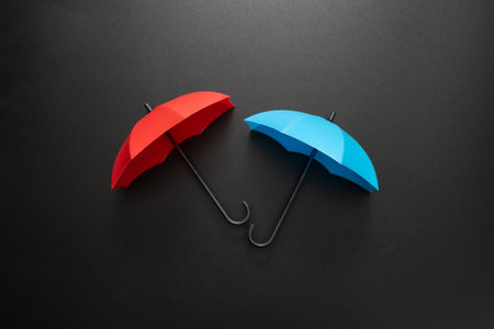 Opened red and blue umbrellas isolated on blank black backgroundの写真素材