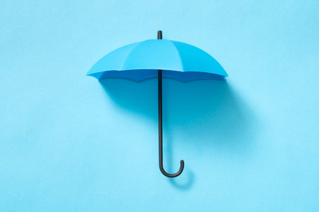 Opened blue umbrella isolated on blank blue backgroundの写真素材