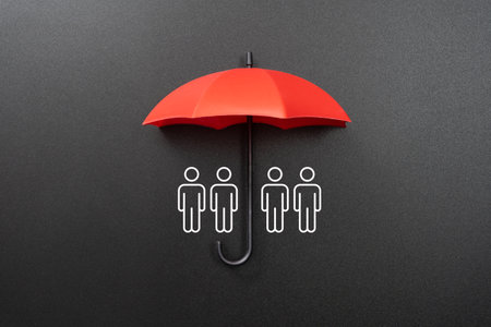 Opened red umbrella isolated on black background with chalk drawn figures underneathの写真素材
