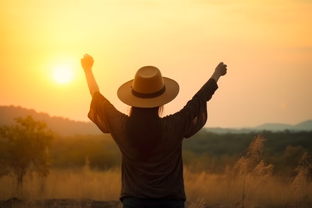 Backview of young woman wearing hat raising hands up to sky, Generative AIの素材