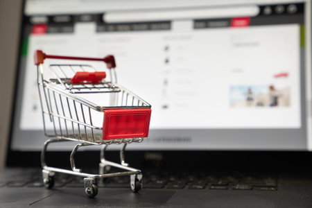 Laptop with a small red shopping cart for e-commerce or online shopping concept.の写真素材